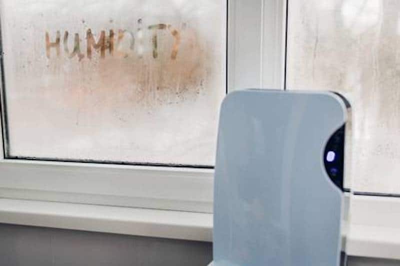 A window with condensation and a dehumidifier